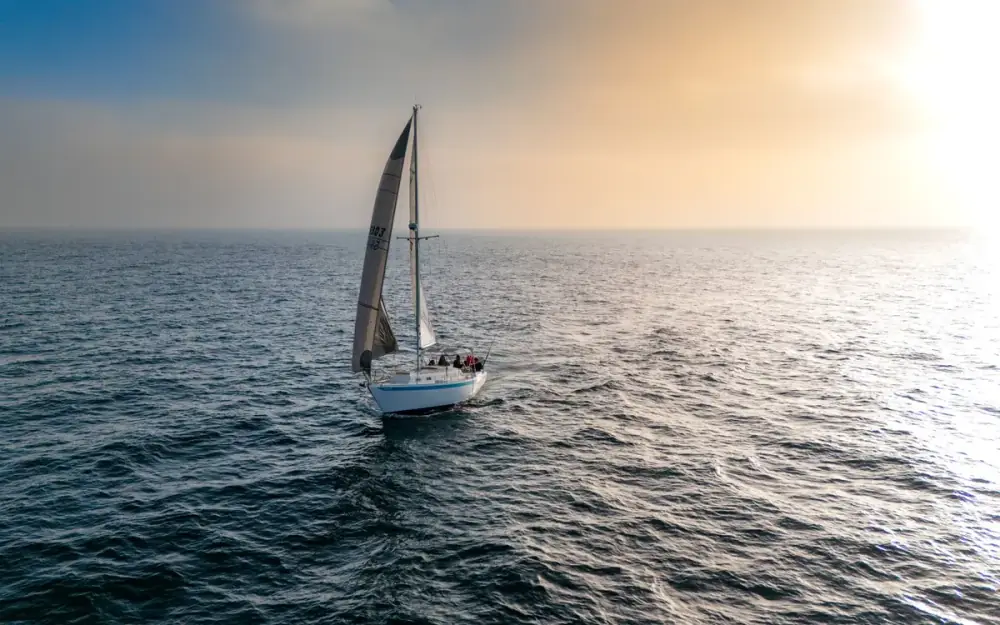 Voilier toutes voiles dehors au coucher du soleil